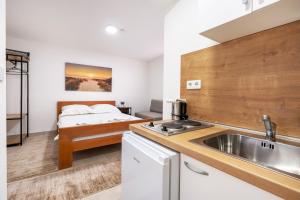 a kitchen with a sink and a bed in a room at Apartments Sunce in Neum