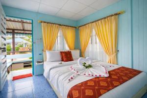 a bedroom with a bed with a flower on it at Phetmanee Resort in Ko Yao Noi +47 photos