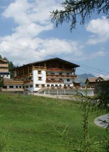 a building on a hill next to a field at Sonnenhotel Soldanella Sonneck in Samnaun