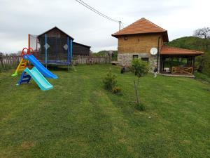 a yard with a playground and a house at Etno kuća Ostrvica in Varnice
