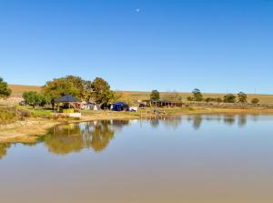 a large body of water with houses in the background at Bietjiedam's Campsites in Caledon