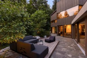 a patio with couches and chairs in front of a house at Villa Jasna in Kranjska Gora