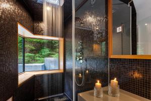 a bathroom with a shower and two candles on a sink at Villa Jasna in Kranjska Gora