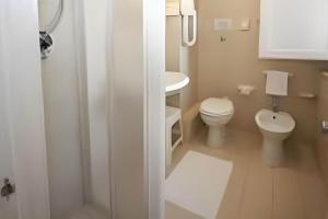 a white bathroom with a toilet and a sink at Hotel Santa Caterina in Marina di Campo +69 photos