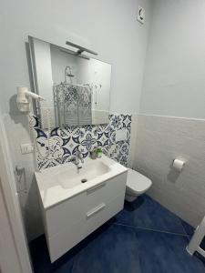 a white bathroom with a sink and a toilet at Hotel La Giara in Zambrone +52 photos