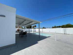 a patio with a table and chairs and a pool at Casa Miamar I in Campano