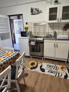 a kitchen with a stove and a table with a rug at Furó Vendégház in Fülöp