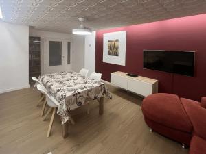 a dining room with a table and a flat screen tv at Pedro in Roses