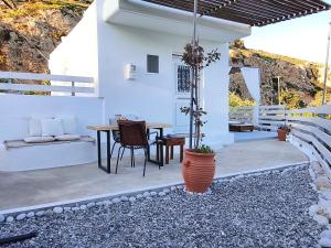 a patio with a table and chairs and a house at Filia Bungalow in Archangelos
