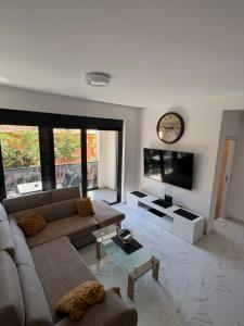 a living room with a couch and a clock on the wall at Ivanovica in Đenovići