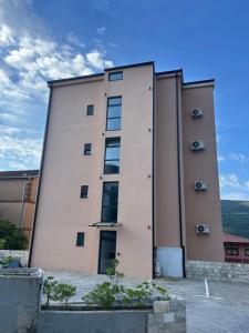 a tall building with windows on the side of it at Ivanovica in Đenovići