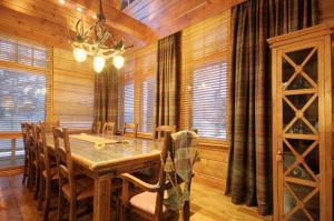 a dining room with a table and chairs and windows at KULAUS in Tahkovuori