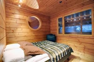 a small room with a bed in a log cabin at KULAUS in Tahkovuori