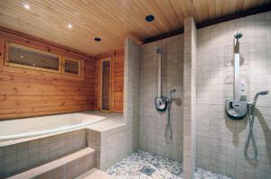 a bathroom with a bath tub and a shower at KULAUS in Tahkovuori +7 photos