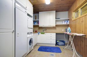 a kitchen with white appliances and a blue rug at KULAUS in Tahkovuori
