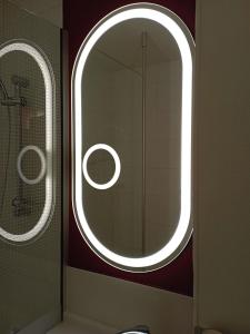 a bathroom with a round mirror and a window at IBIS Fourmies in Fourmies +114 photos