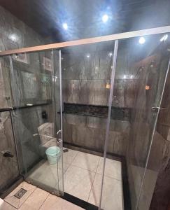 a shower with a glass door in a bathroom at The Pebble Shack in Idukki