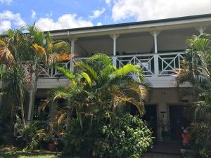 a white house with palm trees in front of it at Waterfront Lodge in Nuku‘alofa