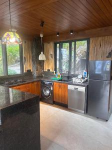 a kitchen with a stainless steel refrigerator and a dishwasher at The Pebble Shack in Idukki +16 photos