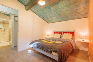 a bedroom with a bed with a wooden ceiling at Mas du soleil levant in Les Vans +13 photos