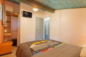 a bedroom with a bed and a tv on the wall at Mas du soleil levant in Les Vans