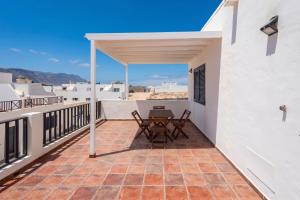a patio with a table and chairs on a balcony at GuestReady - Marea La Graciosa relax para familias in Caleta de Sebo +58 photos