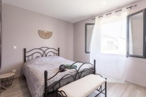 a white bedroom with a bed and a window at Maison Lahourcade in Lahourcade
