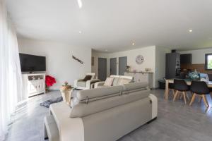 a living room with a white couch and a table at Maison Lahourcade in Lahourcade