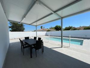 a patio with a table and chairs and a pool at Casa Miamar II in Campano