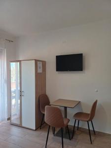 a room with a table and chairs and a television on the wall at Apartments Antonio in Neum