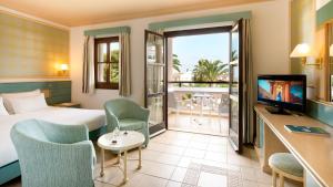 a hotel room with a bed and a balcony at Mitsis Royal Mare in Hersonissos