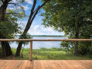 a wooden deck with a view of a lake at Buffalo Tented Camps in Mahango
