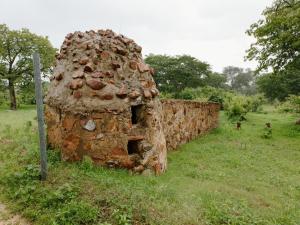 an old stone wall is sitting in a field at Buffalo Tented Camps in Mahango +16 photos