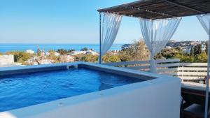 a swimming pool with a view of the ocean at Filia Bungalow in Archangelos
