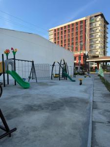 ein Spielplatz auf einem Parkplatz neben einem Gebäude in der Unterkunft Ana condo at Primeworld District in Agus + 7 Fotos