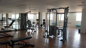 ein Fitnessstudio mit mehreren Laufbändern und Geräten in einem Raum in der Unterkunft Ana condo at Primeworld District in Agus