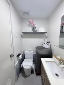 ein weißes Badezimmer mit Toilette und Waschbecken in der Unterkunft Ana condo at Primeworld District in Agus