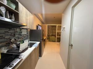 eine Küche mit Herd und Kühlschrank in der Unterkunft Ana condo at Primeworld District in Agus