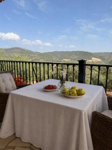 a table with two bowls of fruit on a balcony at Cortijo Sol y Olivo spacious exclusive private pool retreat in Algarinejo