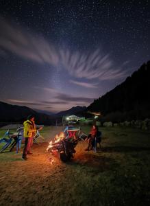 a group of people sitting around a campfire at night at Adventure valley Rajgundha in Kangra
