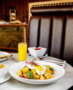 a plate of food with eggs on a table at The Edinburgh Grand, a Luxury Collection Hotel, Edinburgh in Edinburgh