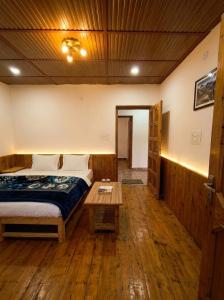 a bedroom with a bed and a wooden floor at Adventure valley Rajgundha in Kangra +3 photos