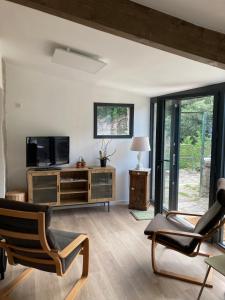 a living room with a television and two chairs at Gîte du Banissou Chez Papy in Rosis