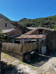 a house with a wooden fence in front of it at Gîte du Banissou Chez Papy in Rosis