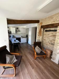 a living room with two chairs and a table at Gîte du Banissou Chez Papy in Rosis