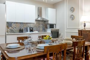 a dining room with a table and chairs and a kitchen at GuestHost - Chic Central Apartment in Montecatini in Montecatini Terme +20 photos
