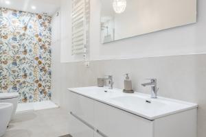 a white bathroom with a sink and a toilet at GuestHost - Chic Central Apartment in Montecatini in Montecatini Terme