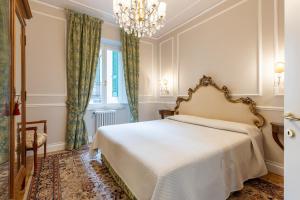 a bedroom with a bed and a chandelier at GuestHost - Chic Central Apartment in Montecatini in Montecatini Terme