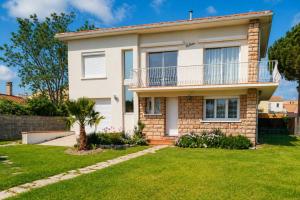 a house with a lawn in front of it at Villa climatisée, proche mer, 2 grands appartements indépendants, parking, WIFI in Le Grau-dʼAgde