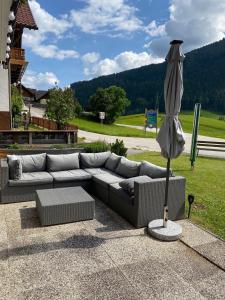 a couch and an umbrella sitting on a patio at Haus Alpentraum in Patergassen